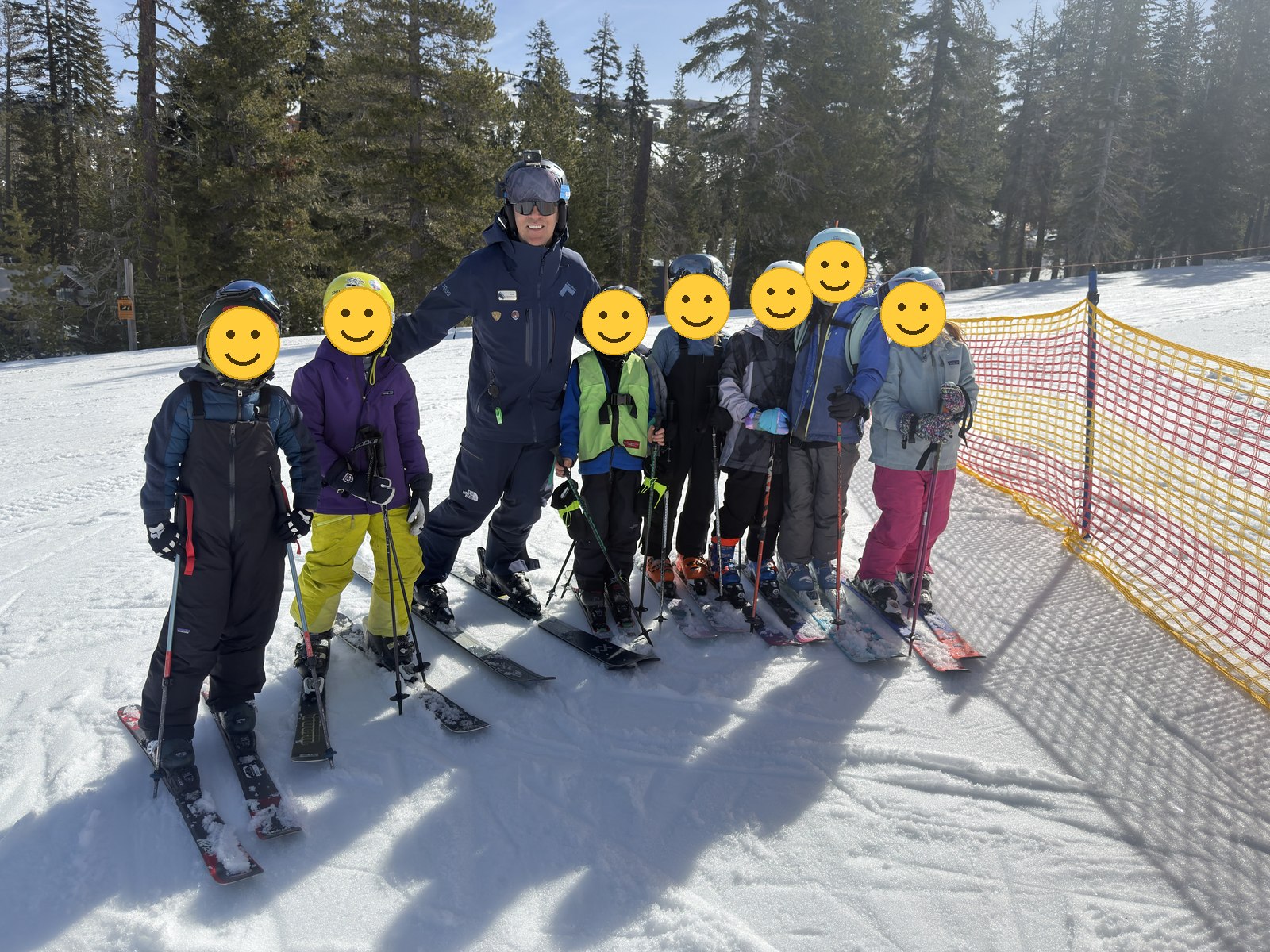 Coach Alex in uniform with a Sugar Bowl Shredders Weekend Program group he coaches, all in helmets, children’s faces covered for privacy