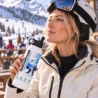 Skier in helmet and goggles drinking from the SkiCoach.Me 30oz tumbler